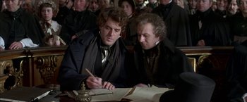 Movie still from “Immortal Beloved” (1994), directed by Bernard Rose – Two men are sitting at a table and one of them is writing; Medium shot, High angle