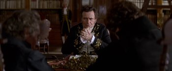 Movie still from “Immortal Beloved” (1994), directed by Bernard Rose – A man sitting at a table in front of a table; Medium shot, Over the shoulder angle