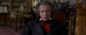 Movie still from “Immortal Beloved” (1994), directed by Bernard Rose – A person sitting in a chair wearing a suit; Close Up shot, Low angle
