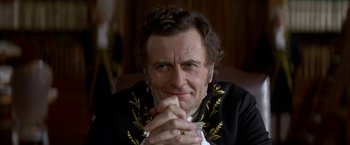 Movie still from “Immortal Beloved” (1994), directed by Bernard Rose – An older man is sitting with his hands clasped together; Close Up shot, Low angle