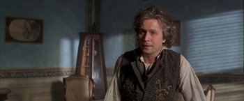 Movie still from “Immortal Beloved” (1994), directed by Bernard Rose – A man in a brown vest standing next to a chair; Close Up shot, Over the shoulder angle