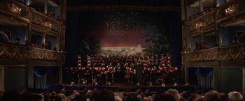 Movie still from “Immortal Beloved” (1994), directed by Bernard Rose – A large group of people are sitting on a stage; Extreme Wide shot, High angle