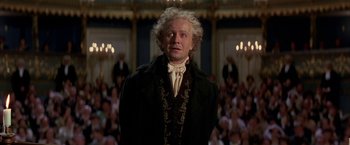 Movie still from “Immortal Beloved” (1994), directed by Bernard Rose – A man standing in front of an audience wearing a suit; Medium shot, Low angle