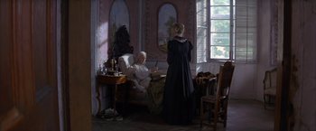 Movie still from “Immortal Beloved” (1994), directed by Bernard Rose – An old woman sitting on a bed next to an old woman; Wide shot, High angle