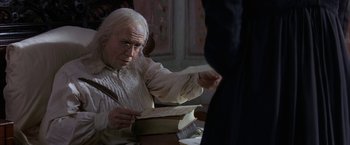Movie still from “Immortal Beloved” (1994), directed by Bernard Rose – An old man sitting at a table with a book in his hands; Close Up shot, Over the shoulder angle
