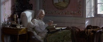 Movie still from “Immortal Beloved” (1994), directed by Bernard Rose – An old man sitting in a chair reading a book; Medium shot, High angle