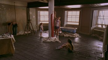 Movie still from “In America” (2002), directed by Jim Sheridan – A woman and two children are painting a pole; Wide shot, High angle