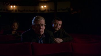 Movie still from “In America” (2002), directed by Jim Sheridan – Two men are sitting in a movie theater; Medium shot, Low angle