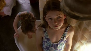 Movie still from “In America” (2002), directed by Jim Sheridan – A young girl looking into a mirror while another girl looks on; Close Up shot, Over the shoulder angle