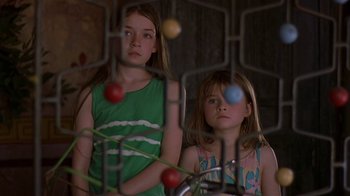 Movie still from “In America” (2002), directed by Jim Sheridan – Two young girls are looking through a fence; Close Up shot, Low angle
