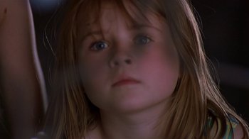 Movie still from “In America” (2002), directed by Jim Sheridan – A young girl's face looking at the camera; Close Up shot, Low angle