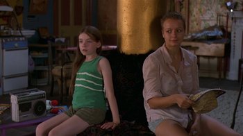 Movie still from “In America” (2002), directed by Jim Sheridan – Two young girls sitting next to each other in front of a fire place; Medium shot, Over the shoulder angle
