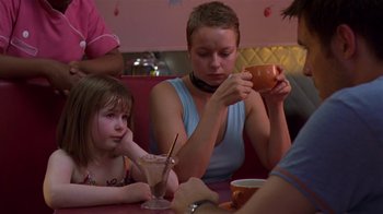 Movie still from “In America” (2002), directed by Jim Sheridan – Two women and a child sitting at a table; Medium shot, Over the shoulder angle