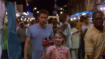 Movie still from “In America” (2002), directed by Jim Sheridan – A man and a little girl holding up a camera; Medium shot, Over the shoulder angle