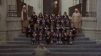 Movie still from “In America” (2002), directed by Jim Sheridan – A group of school children sitting on the steps of a building; Wide shot, High angle