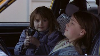 Movie still from “In America” (2002), directed by Jim Sheridan – Two little girls sitting in the back seat of a car; Close Up shot, Over the shoulder angle