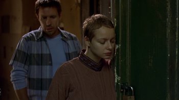 Movie still from “In America” (2002), directed by Jim Sheridan – A man and a woman standing next to each other in front of a building; Medium shot, Over the shoulder angle