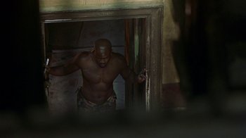 Movie still from “In America” (2002), directed by Jim Sheridan – A shirtless man standing in front of an open door; Medium shot, High angle