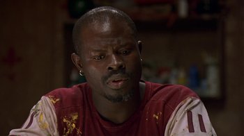 Movie still from “In America” (2002), directed by Jim Sheridan – A person sitting down with food on his face; Close Up shot, Low angle