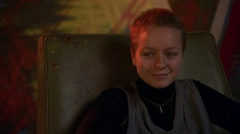 Movie still from “In America” (2002), directed by Jim Sheridan – A woman with short blonde hair sitting on a couch; Close Up shot, High angle
