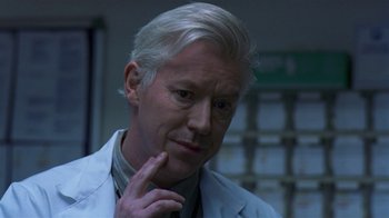 Movie still from “In America” (2002), directed by Jim Sheridan – An older man in a lab coat looks at the camera; Close Up shot, Low angle
