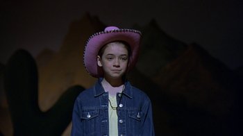 Movie still from “In America” (2002), directed by Jim Sheridan – A young girl wearing a cowboy hat in front of mountains; Medium shot, High angle