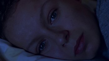 Movie still from “In America” (2002), directed by Jim Sheridan – A person's face in the dark; Close Up shot, Overhead angle