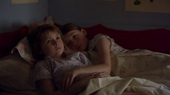 Movie still from “In America” (2002), directed by Jim Sheridan – Two young girls laying in a bed together; Medium shot, High angle