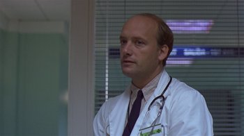 Movie still from “In America” (2002), directed by Jim Sheridan – A man wearing a white lab coat and a stethoscope; Close Up shot, Low angle