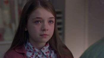 Movie still from “In America” (2002), directed by Jim Sheridan – A young girl with long brown hair wearing a floral shirt; Close Up shot, Over the shoulder angle