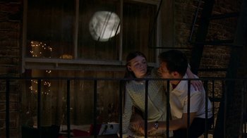 Movie still from “In America” (2002), directed by Jim Sheridan – A man and a woman sitting next to each other on a porch; Medium shot, Low angle