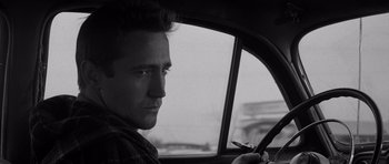 Movie still from “In Cold Blood” (1967), directed by Richard Brooks – A black and white photo of a man driving a car; Close Up shot, Over the shoulder angle