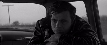 Movie still from “In Cold Blood” (1967), directed by Richard Brooks – Black and white photograph of a man sitting in the back of a car; Close Up shot, Low angle