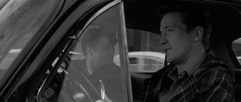 Movie still from “In Cold Blood” (1967), directed by Richard Brooks – A man sitting in the passenger seat of a car; Close Up shot, Over the shoulder angle