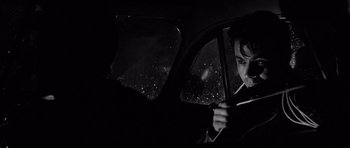 Movie still from “In Cold Blood” (1967), directed by Richard Brooks – A man sitting in the driver's seat of a car at night; Close Up shot, Over the shoulder angle