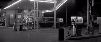 Movie still from “In Cold Blood” (1967), directed by Richard Brooks – A black and white photo of a gas station; Wide shot, High angle