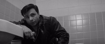 Movie still from “In Cold Blood” (1967), directed by Richard Brooks – A black and white photo of a man in a leather jacket in a bathroom; Close Up shot, Low angle