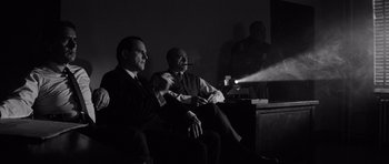 Movie still from “In Cold Blood” (1967), directed by Richard Brooks – Two men sitting on a couch in front of a projector; Medium shot, Low angle