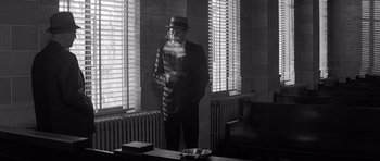 Movie still from “In Cold Blood” (1967), directed by Richard Brooks – A black and white photo of a man smoking a pipe; Wide shot, Low angle