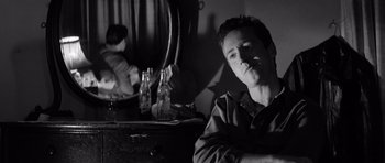 Movie still from “In Cold Blood” (1967), directed by Richard Brooks – A man sitting in front of a mirror smoking a cigarette; Close Up shot, Low angle