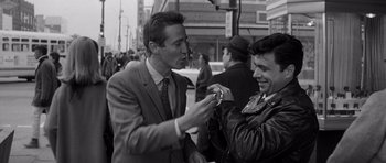 Movie still from “In Cold Blood” (1967), directed by Richard Brooks – Two men in suits are talking to each other on the street; Medium shot, High angle