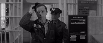 Movie still from “In Cold Blood” (1967), directed by Richard Brooks – A man in a uniform saluting in front of another man in a uniform; Close Up shot, Over the shoulder angle