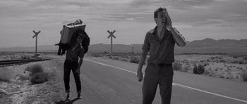 Movie still from “In Cold Blood” (1967), directed by Richard Brooks – Two men walking down a road near a railroad crossing; Wide shot, Low angle