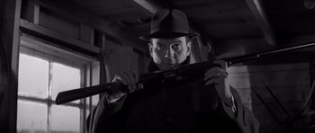 Movie still from “In Cold Blood” (1967), directed by Richard Brooks – A black and white photo of a man holding a rifle; Close Up shot, Low angle