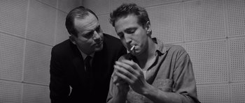 Movie still from “In Cold Blood” (1967), directed by Richard Brooks – A man smoking a cigarette next to another man; Close Up shot, Low angle