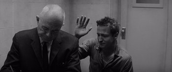 Movie still from “In Cold Blood” (1967), directed by Richard Brooks – Two men in a room with one of them holding his hand up to the other; Close Up shot, Over the shoulder angle