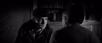 Movie still from “In Cold Blood” (1967), directed by Richard Brooks – A man wearing a hat talking to another man in front of him; Close Up shot, Over the shoulder angle