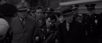 Movie still from “In Cold Blood” (1967), directed by Richard Brooks – Black and white photograph of a group of men in hats; Medium shot, High angle