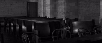 Movie still from “In Cold Blood” (1967), directed by Richard Brooks – An older man sitting in a chair in front of a window; Wide shot, High angle