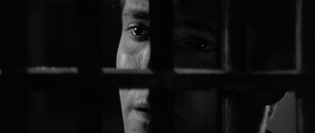Movie still from “In Cold Blood” (1967), directed by Richard Brooks – A person's face behind bars; Extreme Close Up shot, Low angle
